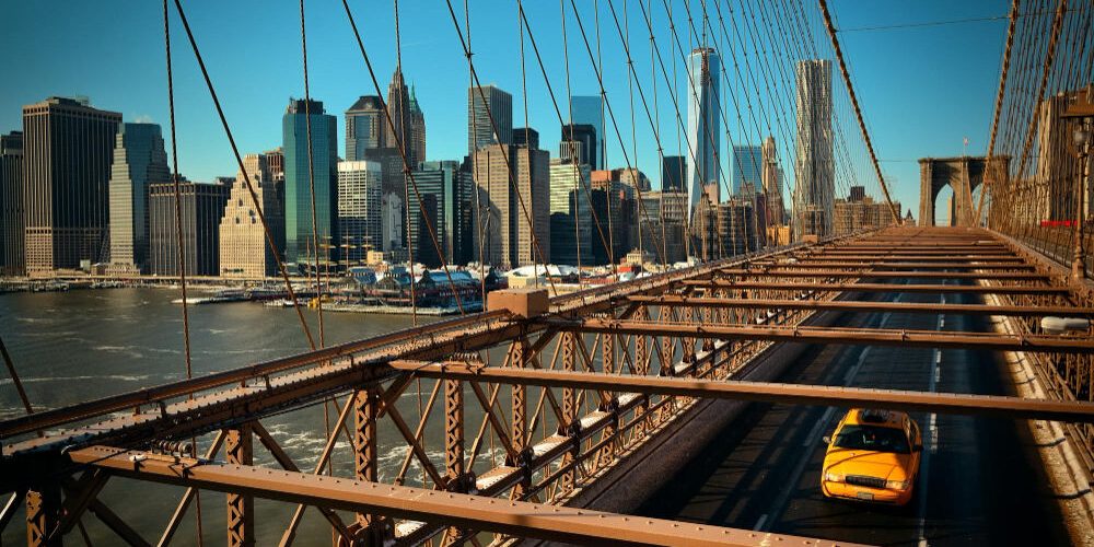 A suspension bridge on the route from Manhattan to JFK with the view of the city at the background A suspension bridge on the route from Manhattan to JFK with the view of the city at the background
