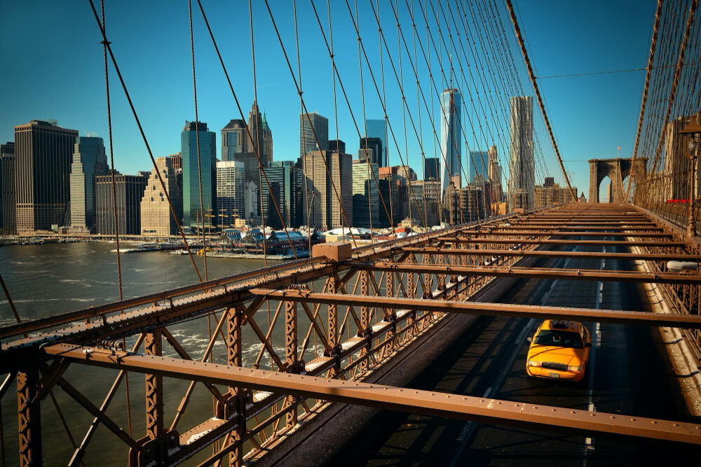 A suspension bridge on the route from Manhattan to JFK with the view of the city at the background