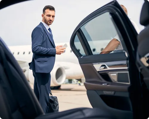 An NYC United limo airport service chauffeur is happily waiting for the client while ensuring that things are perfect for when the client will arrive