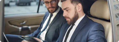 Two business executive having a business meeting while commuting in a corporate limo