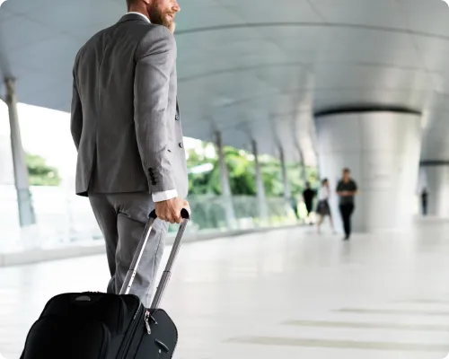 A professional chauffeur is managing a client's luggage at the airport