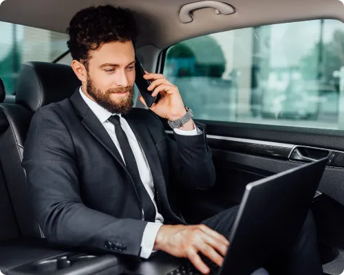 A business executive is attending a meeting while commuting in a limo