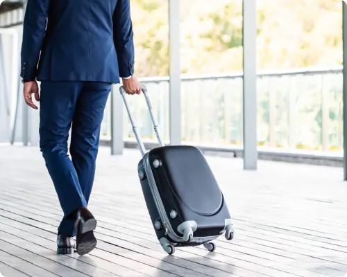 A uniformed chauffeur is managing a luggage at the airport