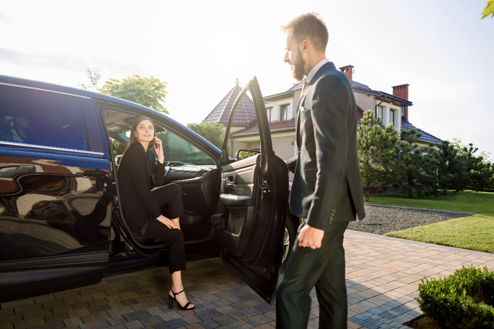 Professional chauffeur assisting a passenger in a luxury car during his trip from LGA to JFK airport.