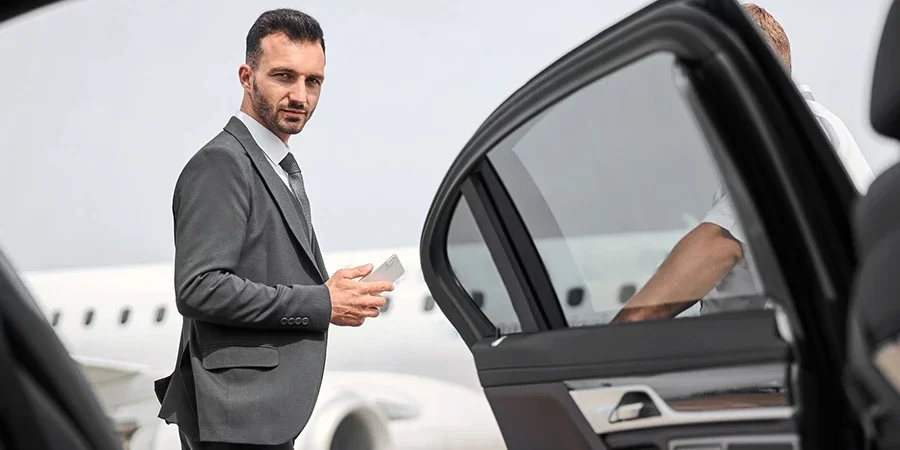 Chauffeur holding car door open, illustrating seamless pre-booked and on-demand convenience offered by reliable LGA Airport Car Service