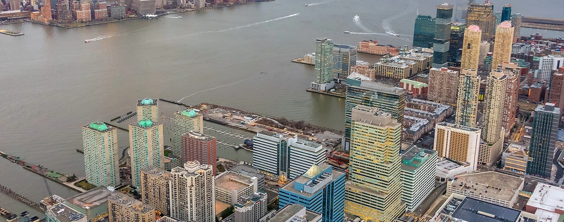 Aerial view of Jersey City waterfront and skyline along the Hudson River, capturing luxury travel options from New York to Jersey City and Atlantic City for beach or casino getaways