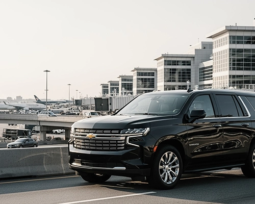Luxury black SUV providing comfortable limo service from JFK to Philadelphia parked at the airport terminal