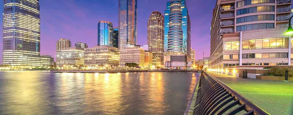 Scenic view of Jersey City skyline and Hudson River waterfront walkway at sunset, highlighting key local stops near New York to Jersey City route like Newport Center Mall and Liberty Science Center
