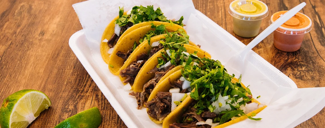 Best Spots for a Quick Bite featuring delicious tacos with cilantro and lime, served with sauces, perfect for a stop during a car service Brooklyn tour.