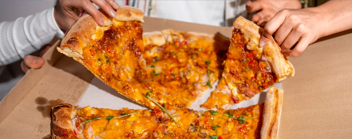 A delicious pizza being shared, highlighting the best spots for a quick bite, with car service Manhattan available for convenient travel to these locations.