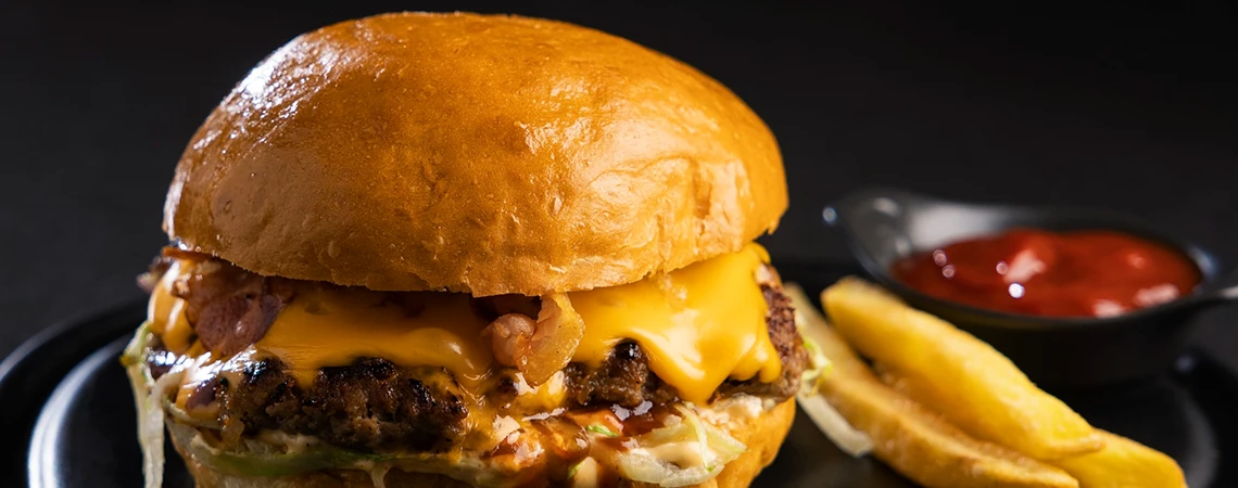 Explore spots for a quick bite in Newark with Newark car service, image featuring a juicy smashburger from Slap Burger.
