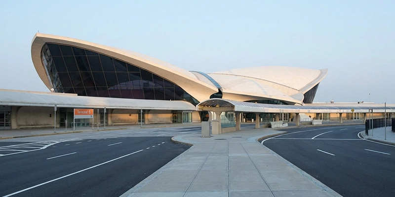 John F. Kennedy International Airport (JFK): The iconic TWA Hotel and Terminal 5 with its distinct curved rooflines and modern glass façade.