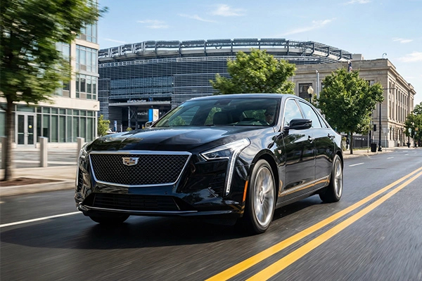 Black Cadillac sedan cruises by grand stadium on sunny day, capturing upscale transport vibe ahead of the FIFA World Cup 2026. Iconic venue ready for the 2026 FIFA World Cup.