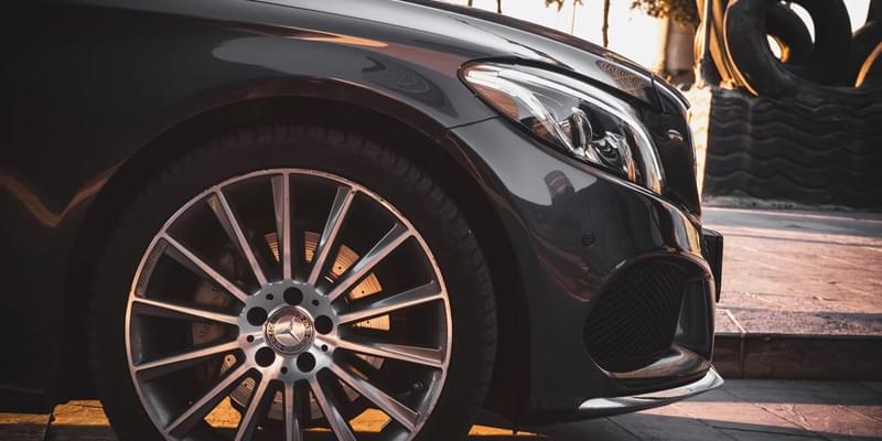 A Side skirt view of a luxury black Mercedes