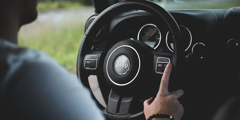 A view of a Jeep steering wheel with the driver getting ready to start the vehicle