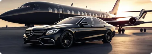 A tilted side and front view of NYC United limo’s Mercedes Benz with a private jet at the background at JFK airport.