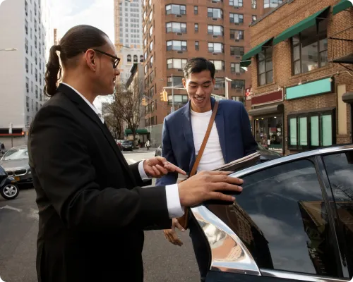 A chauffeur is having a chat with his client while picking him from a New York city street