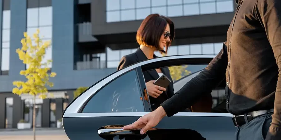 Passenger comfortably assisted by chauffeur, highlighting luggage assistance amenities provided by premium LGA limo service.