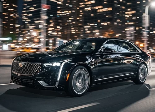 Luxury black Cadillac sedan speeding through Manhattan at night for LGA Airport Transfer, providing premium high-speed executive transportation for clients traveling via LGA to JFK airport transfer.